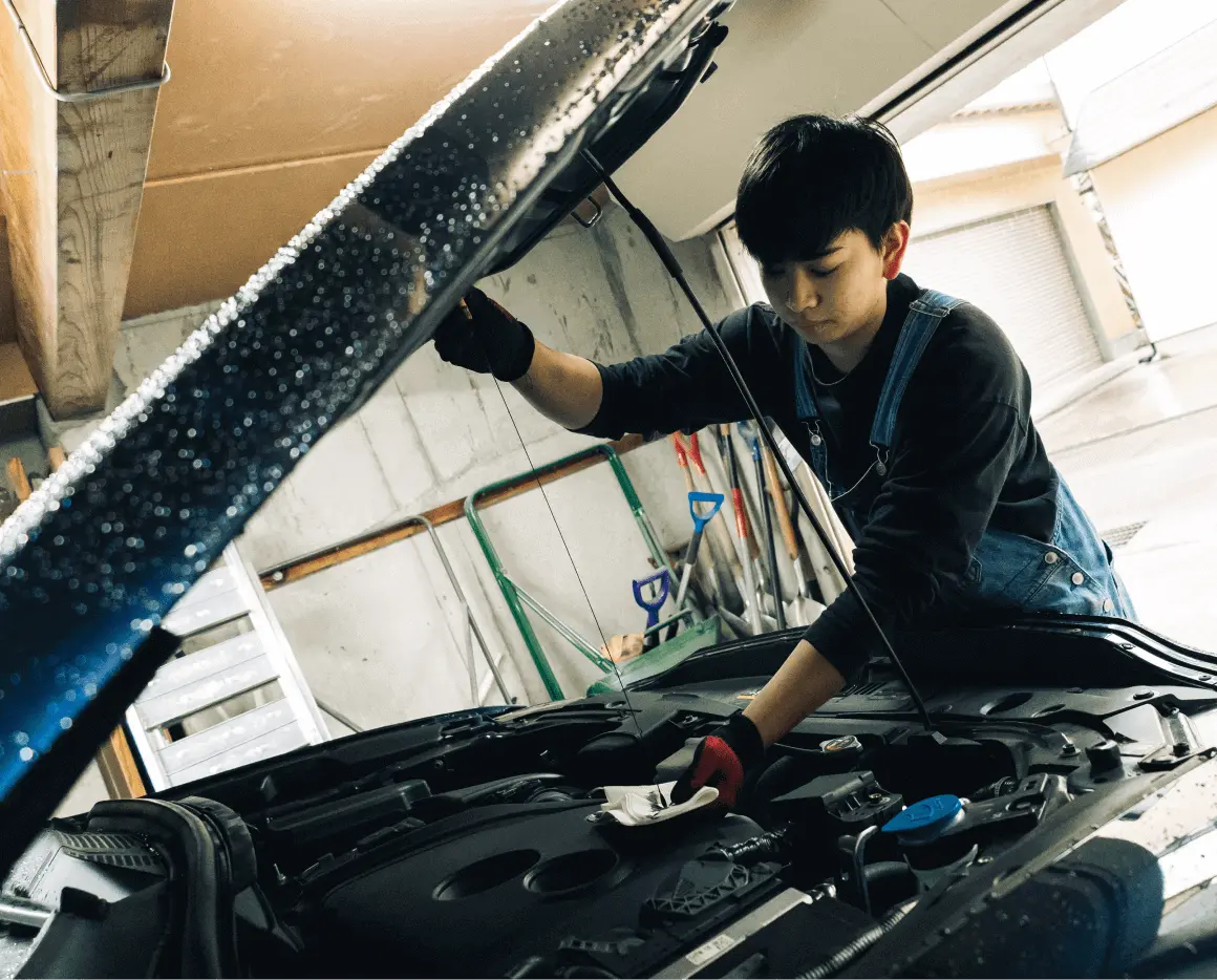 自動車のエンジンルームを整備するスタッフ