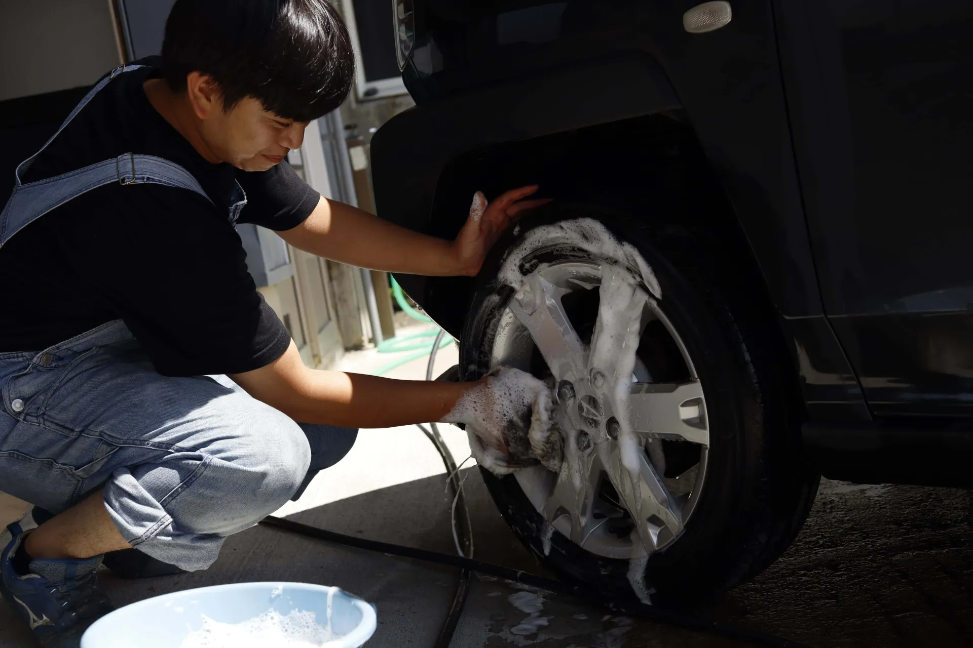自動車のホイールを丁寧に洗浄するスタッフ