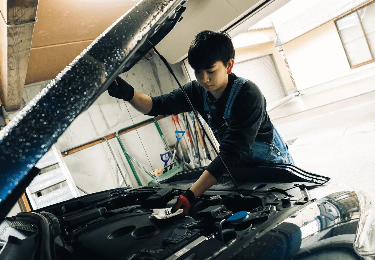 自動車のエンジンルームを点検するスタッフ